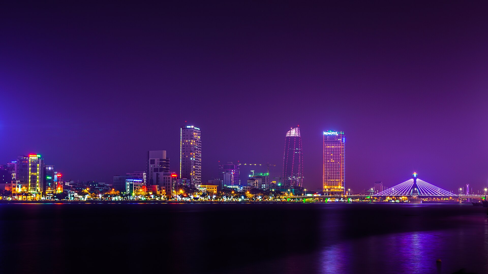Da Nang skyline along the Han River at dusk, with the city's lit bridges