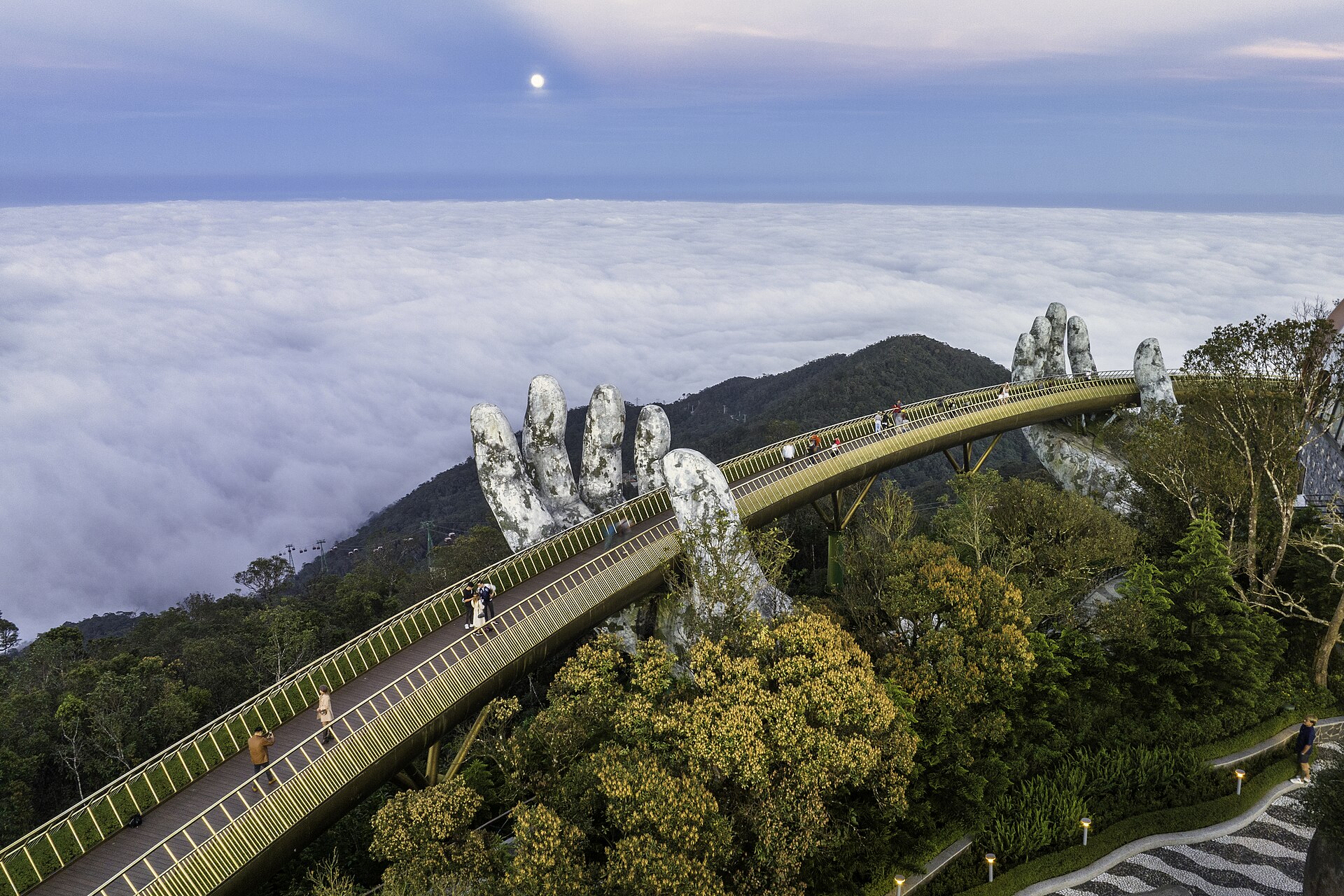 The Golden Bridge held aloft by two giant stone hands, floating above the clouds at Ba Na Hills near Da Nang