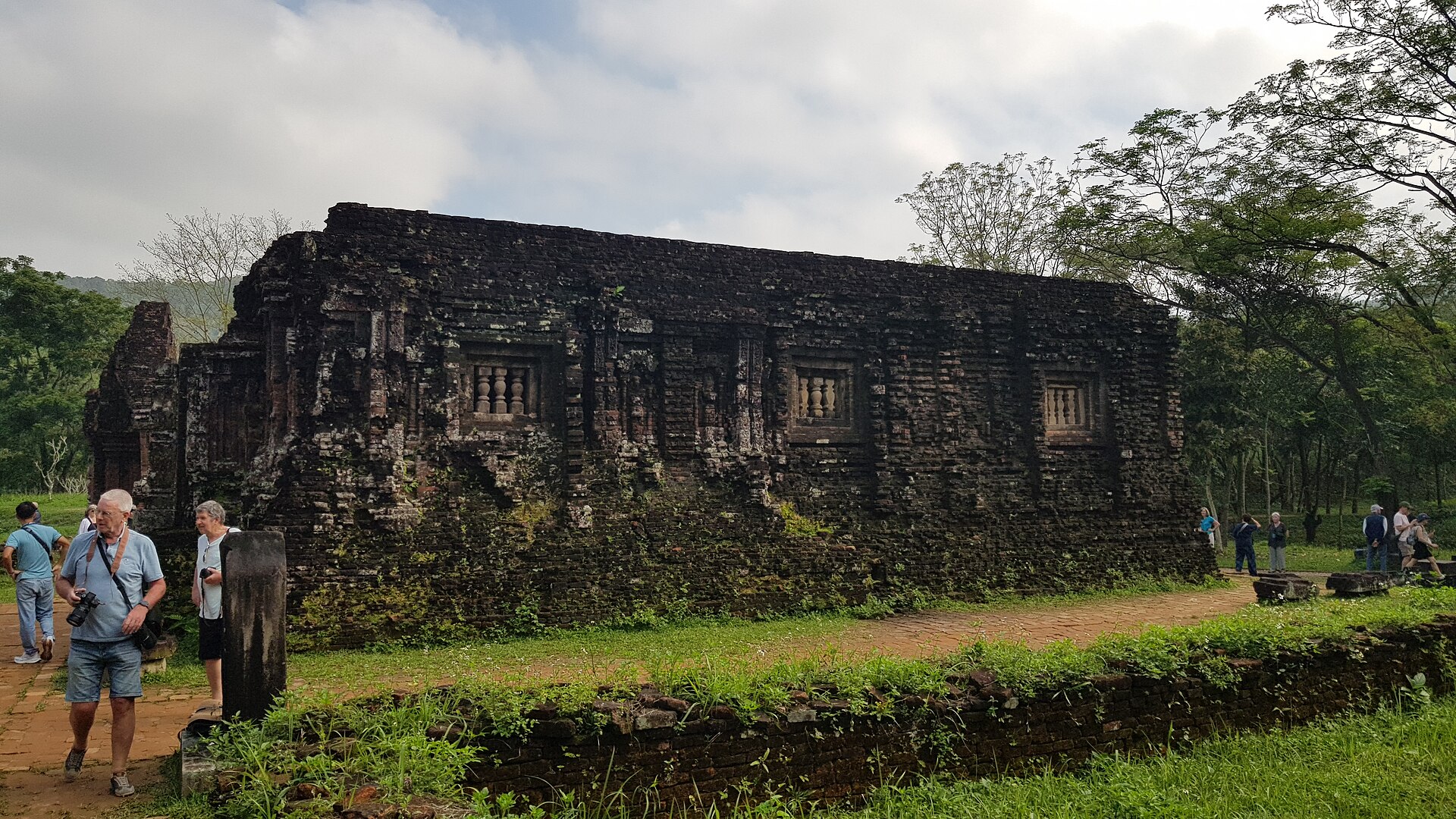 Weathered brick Cham temple towers at the My Son Sanctuary, overgrown with jungle
